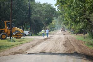 People on dirt road with construction equipment